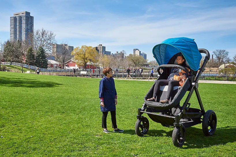 Checking if a folded stroller fits securely inside a small car trunk.