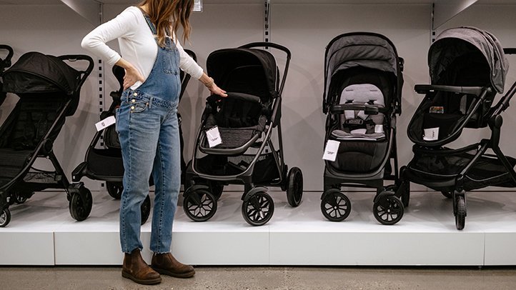 Hands adjusting the front wheel lock on an all-terrain jogging stroller.
