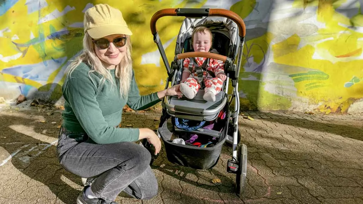 Parents exploring various stroller models in a large baby specialty retail store.