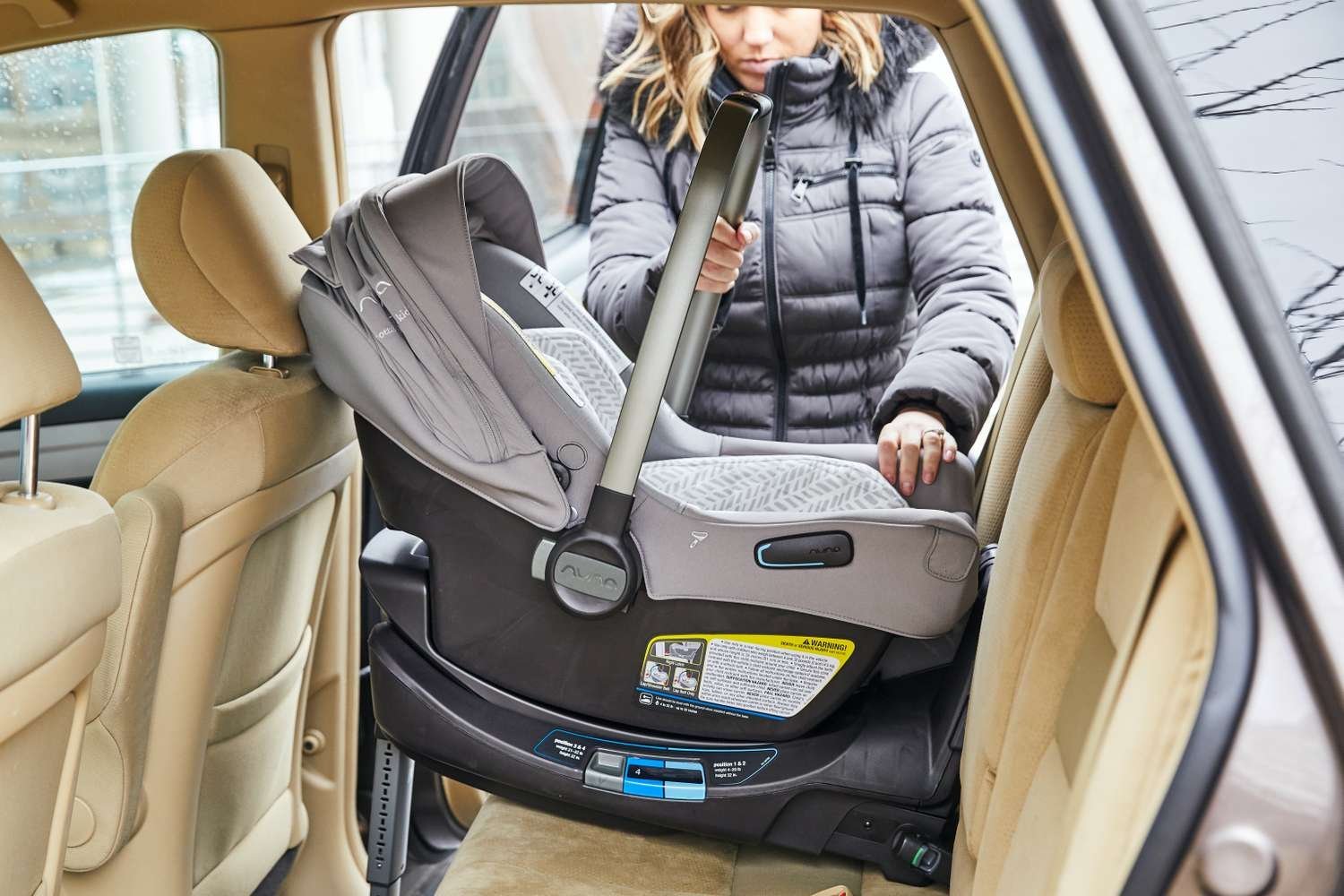 A person measures a car trunk space to ensure a stroller will fit inside.